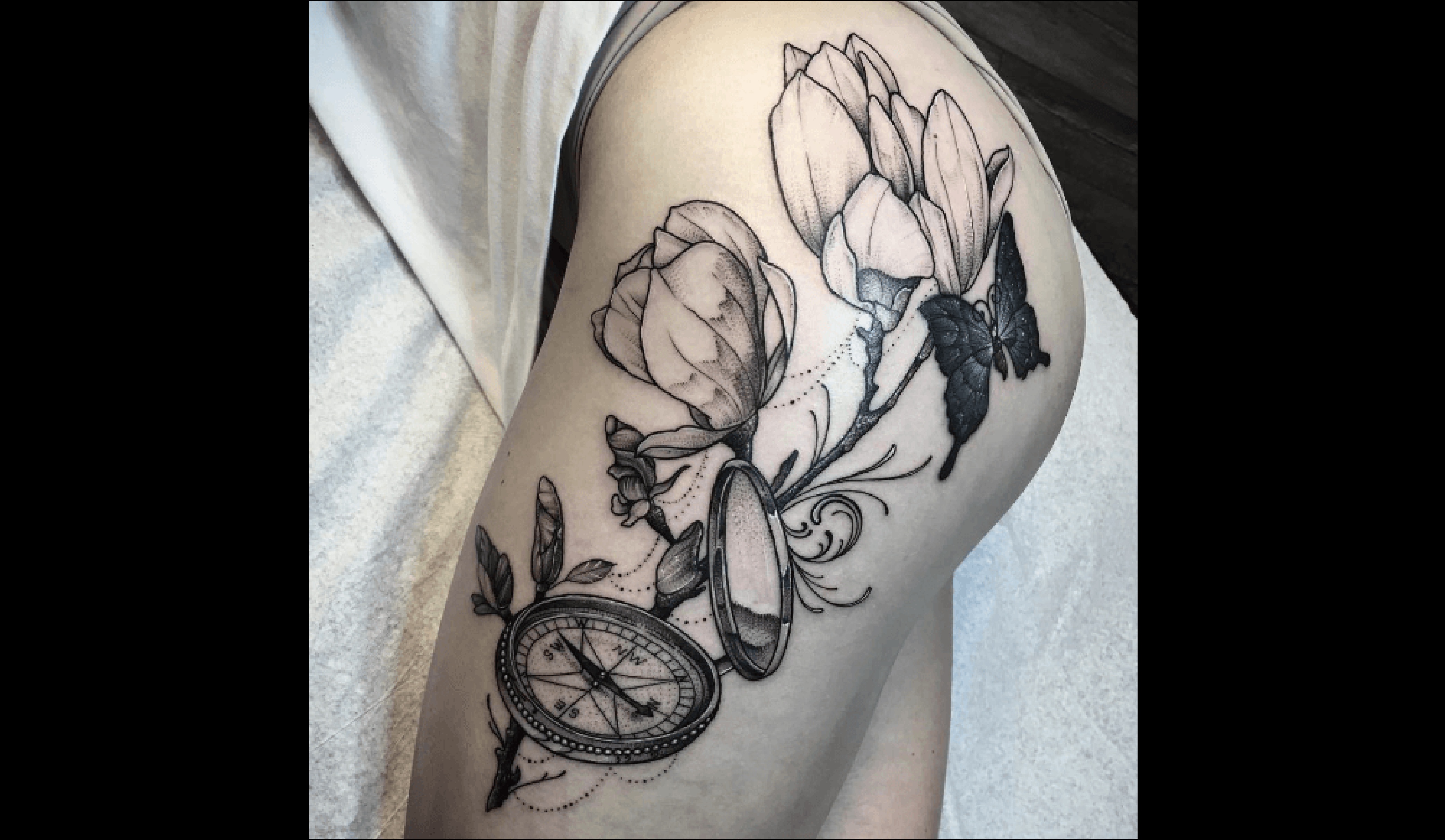 Artiste inconnu, une boussole tatouée sur le haut de la jambe