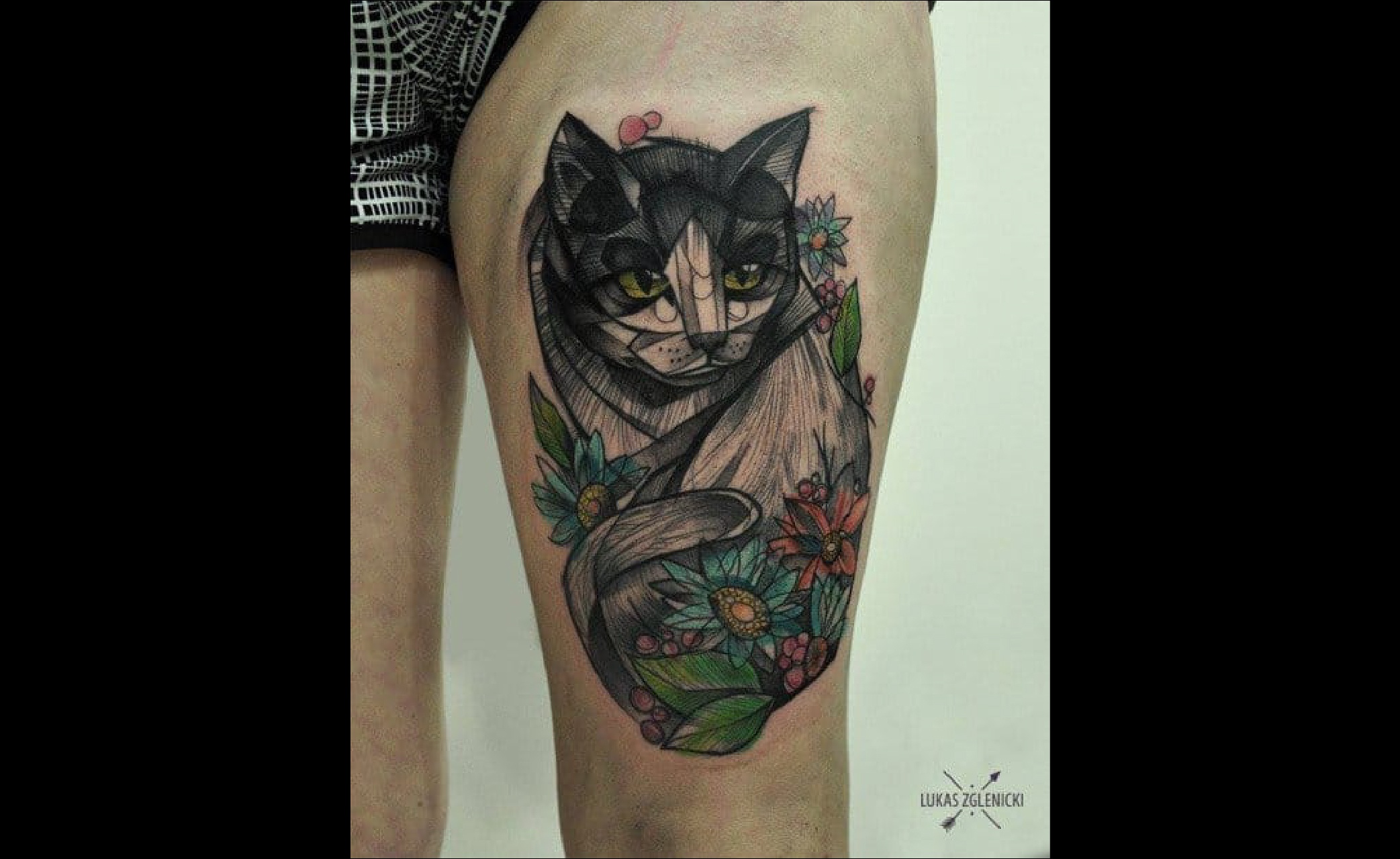 Un chat tatoué sur la jambe dans le style du tatouage graphique